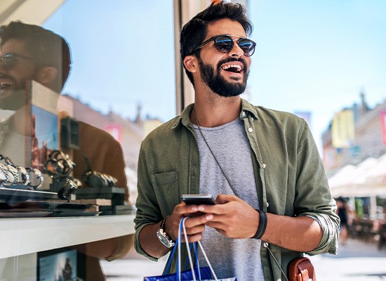 Man smiling while shopping outside