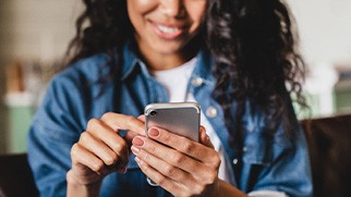Smiling woman looking at phone at home