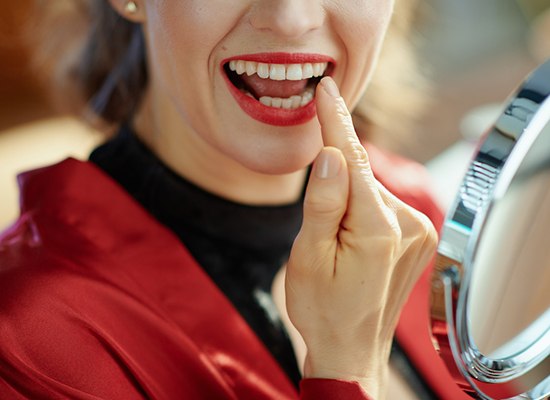 a person checking their teeth after dental bonding