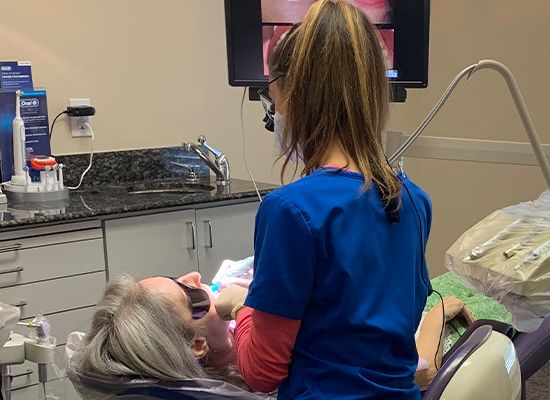 Dental hygienist cleaning patient's teeth