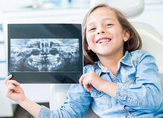 Child holding tablet with digital x-rays