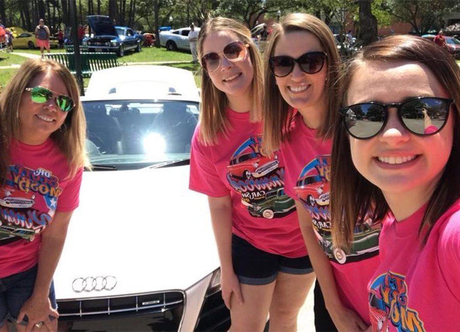 Four team members posing with car at carshow