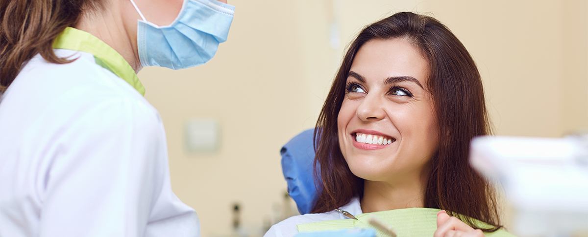 Woman in dental chair smiling at dentist