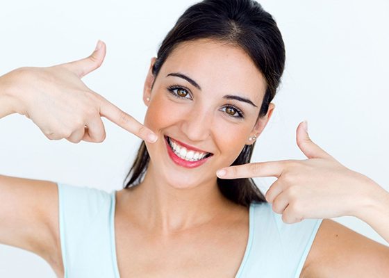 woman pointing to her straight white teeth