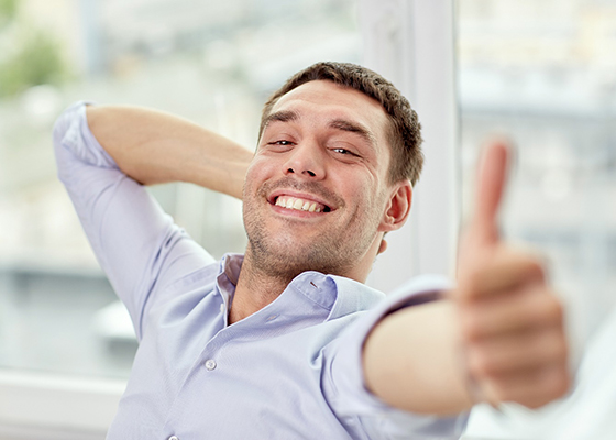 Man leaning back and giving a thumbs up