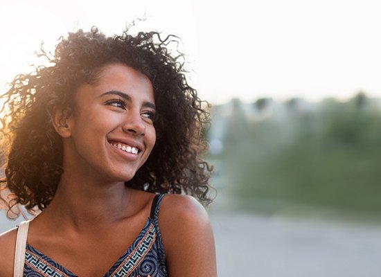 Woman standing outside and smiling while sun is setting