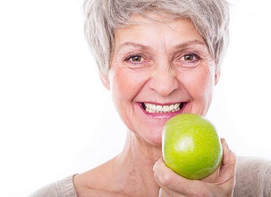 Woman with dentures holding an apple