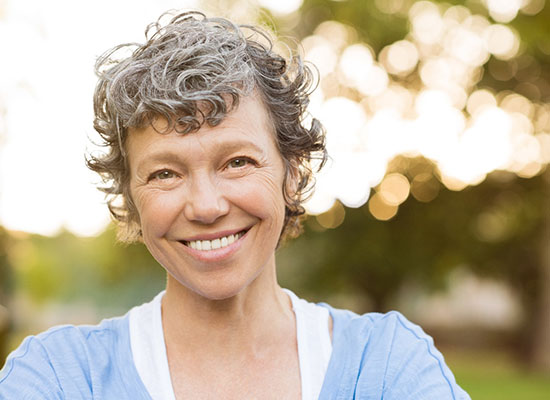 patient smiling after getting dentures in Kingwood 