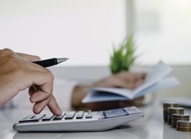 Man using calculator to determine cost of dental emergency in Kingwood