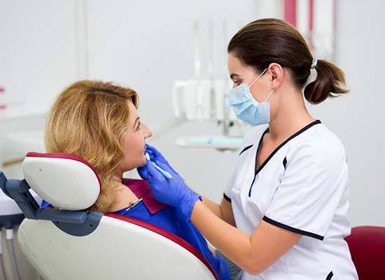 Woman visiting dentist to prevent dental emergencies in Kingwood