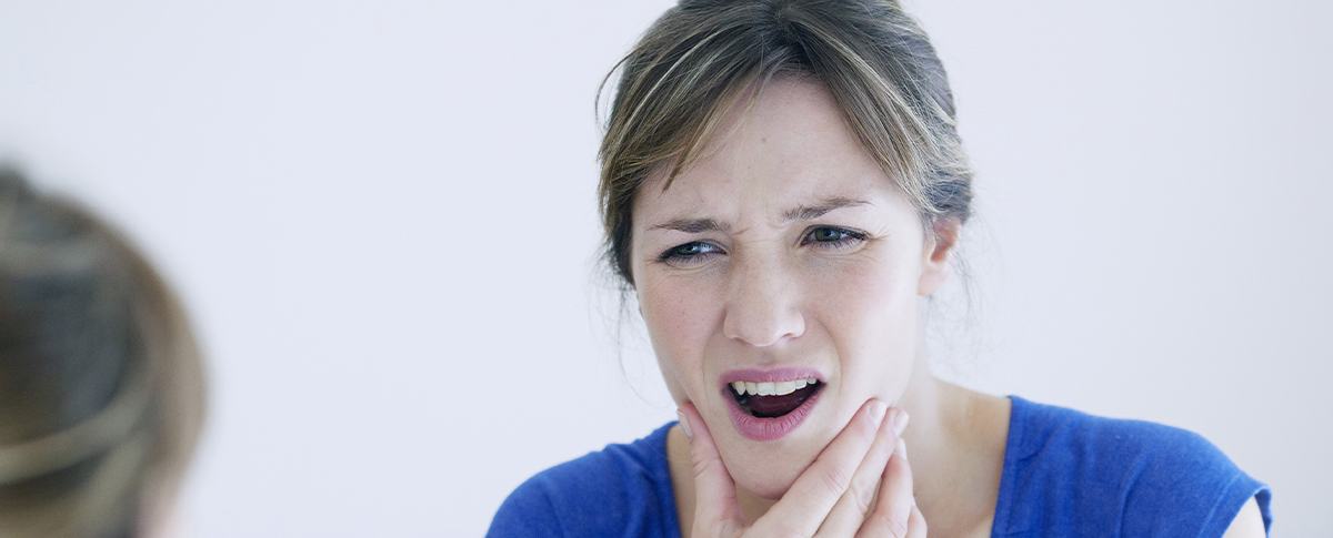 Woman in pain holding jaw