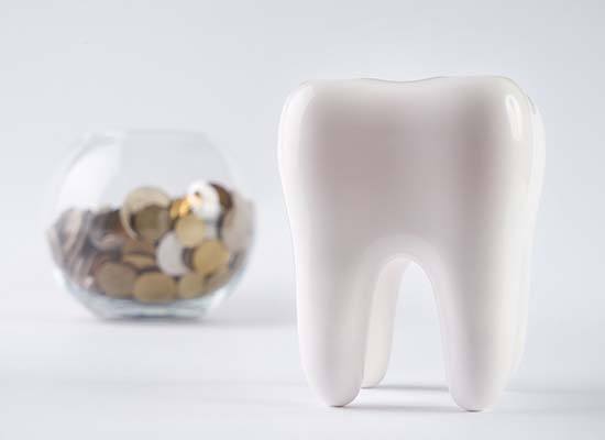 fake tooth next to a jar of coins