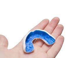 blue mouthguard in a person’s hand