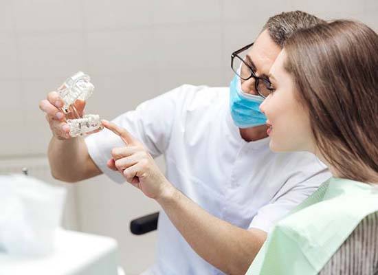 dentist showing a patient how dental implants work