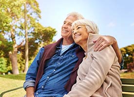 senior couple sitting on a park bench