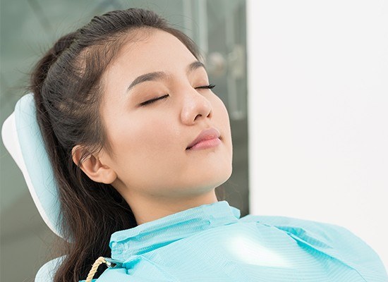 Relaxed woman with eyes closed in dental chair