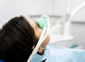 Patient breathing in nitrous oxide while sitting in treatment chair