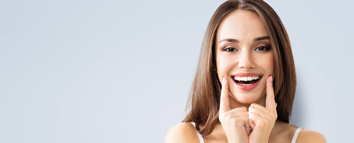 Woman pointing to healthy teeth and gums