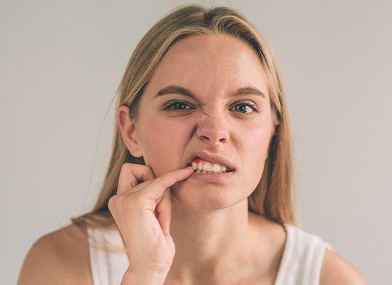 Woman pointing to red gum tissue