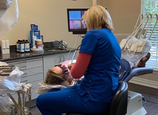 Dental hygienist cleaning patient's teeth
