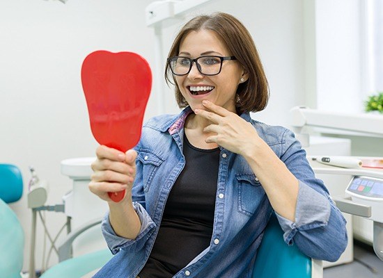 Woman looking at her smile in the mirror