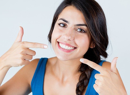 Woman pointing to her flawless smile