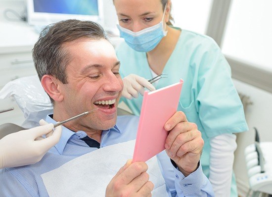 Man looking at smile in mirror