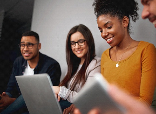 group of friends looking at a laptop