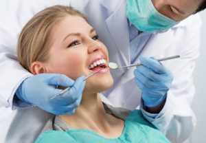 Woman sitting in the dentist chair getting a dental exam